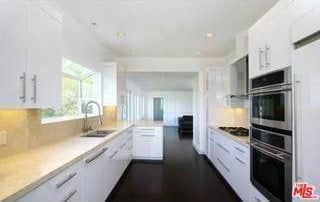 kitchen with white cabinetry, sink, oven, and black electric stovetop