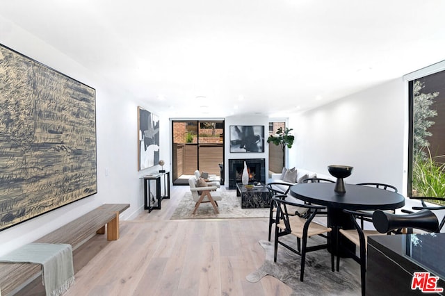 dining room with a wall of windows and light wood-type flooring