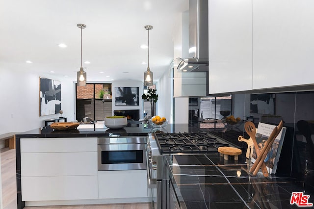 kitchen featuring pendant lighting, stainless steel oven, exhaust hood, and white cabinets