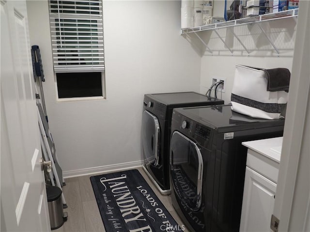 laundry area with hardwood / wood-style flooring and washer and dryer