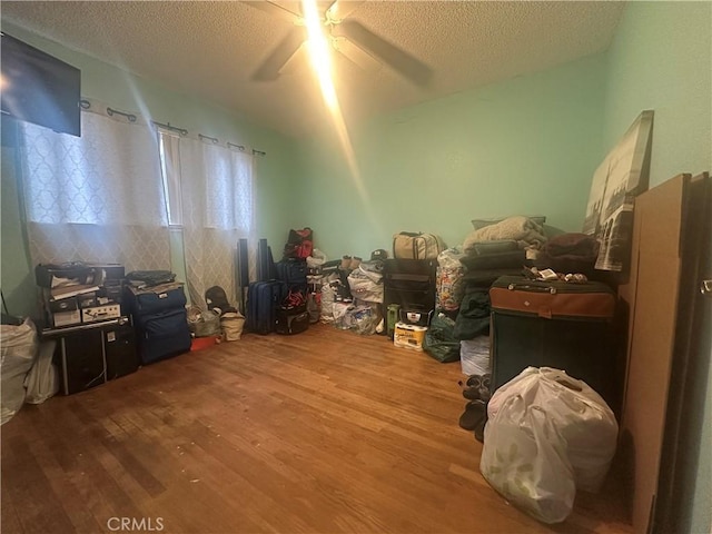 misc room featuring ceiling fan, hardwood / wood-style floors, and a textured ceiling