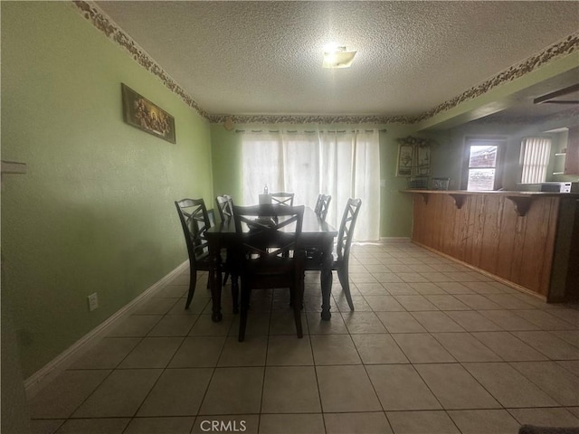 dining area with tile patterned flooring and a textured ceiling