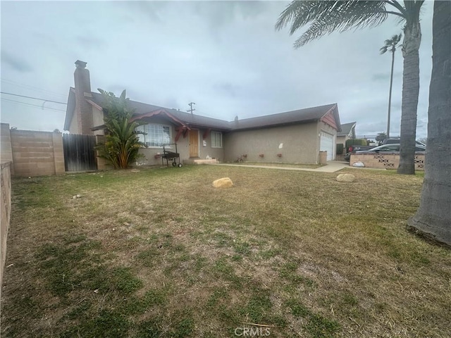 rear view of property featuring a garage and a yard