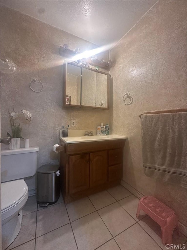 bathroom with tile patterned flooring, vanity, and toilet