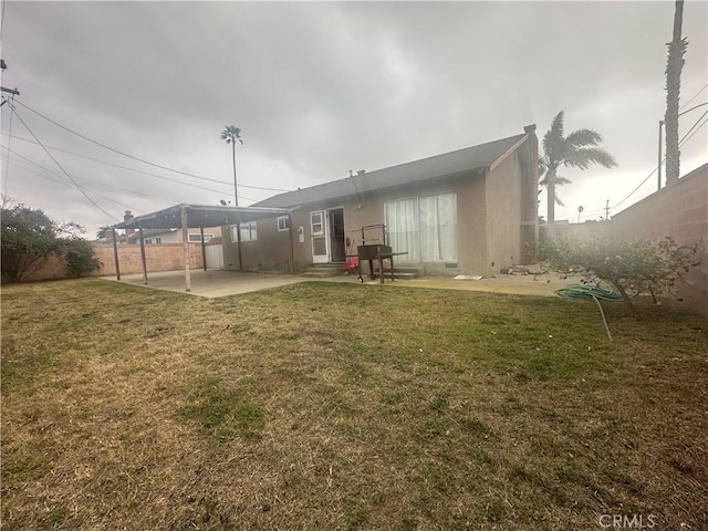 back of house with a patio and a lawn