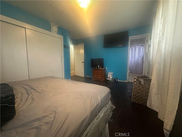 bedroom with a textured ceiling and a closet