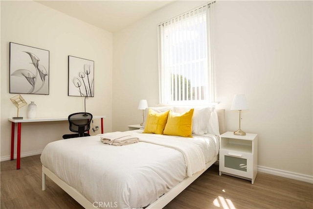 bedroom with dark hardwood / wood-style flooring