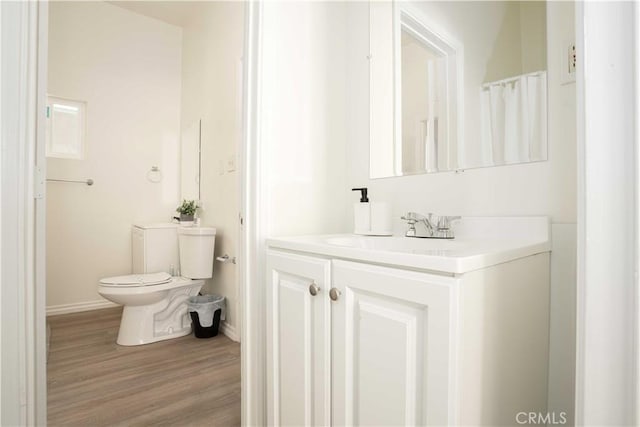 bathroom featuring vanity, hardwood / wood-style floors, and toilet