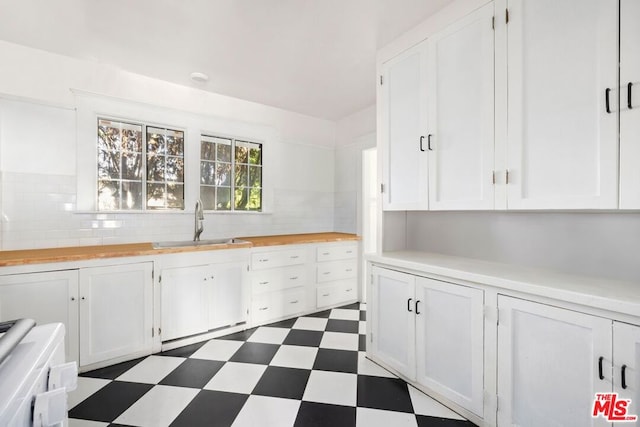 kitchen featuring white cabinetry, sink, and decorative backsplash