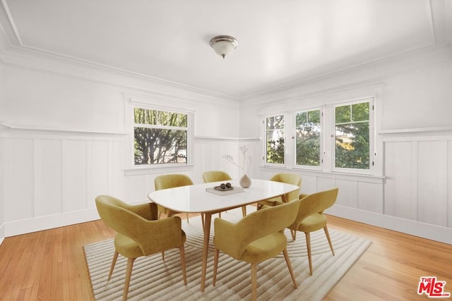 dining room featuring ornamental molding and light wood-type flooring