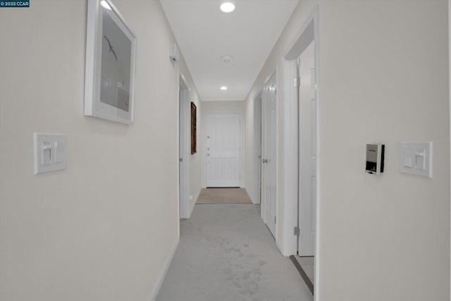 corridor featuring light colored carpet