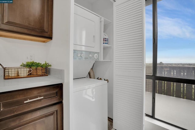 laundry room featuring stacked washer / drying machine