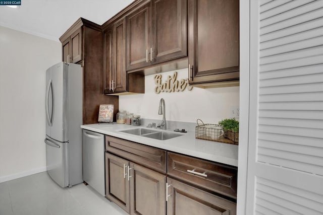 kitchen with sink, crown molding, dark brown cabinets, and appliances with stainless steel finishes