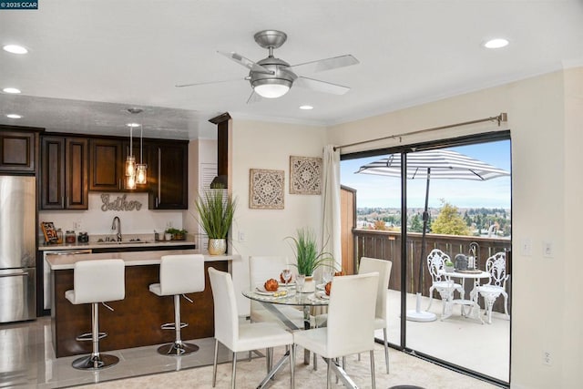 dining area with sink, ornamental molding, and ceiling fan