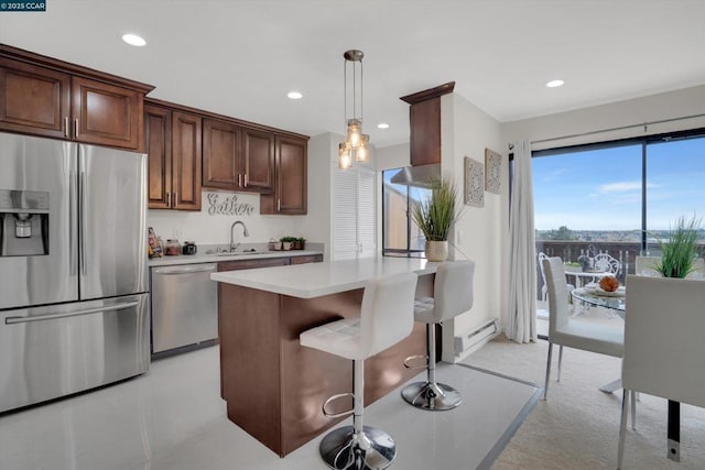 kitchen featuring sink, a center island, a baseboard radiator, pendant lighting, and stainless steel appliances