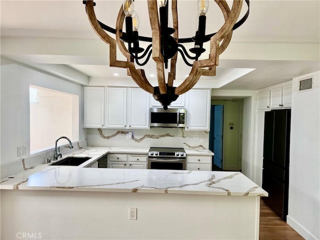 kitchen with sink, stainless steel appliances, white cabinetry, and kitchen peninsula