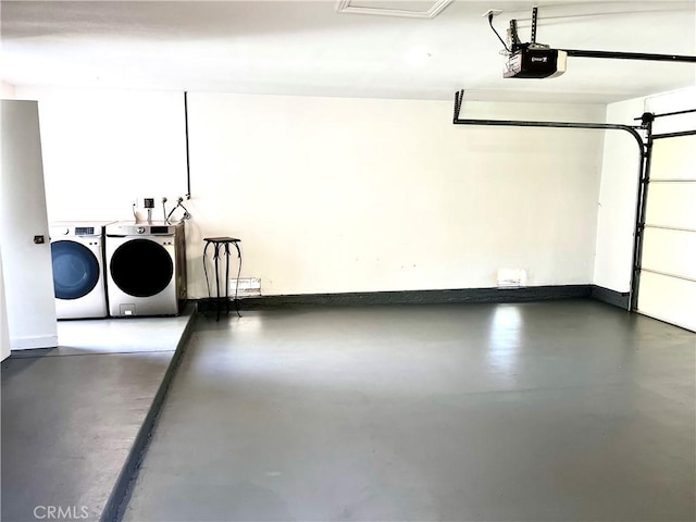 garage featuring baseboards, independent washer and dryer, and a garage door opener