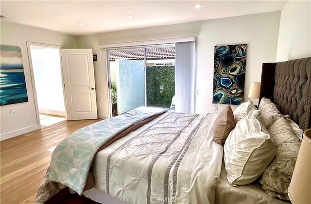 bedroom with access to exterior, baseboards, and wood finished floors