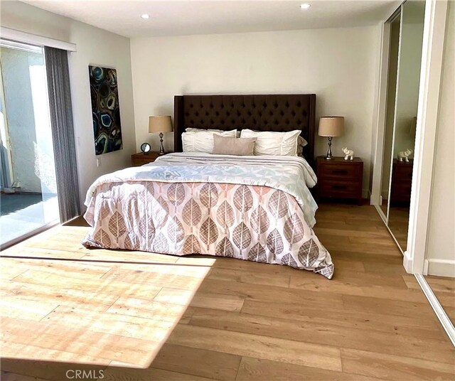 bedroom with access to exterior, wood finished floors, and recessed lighting