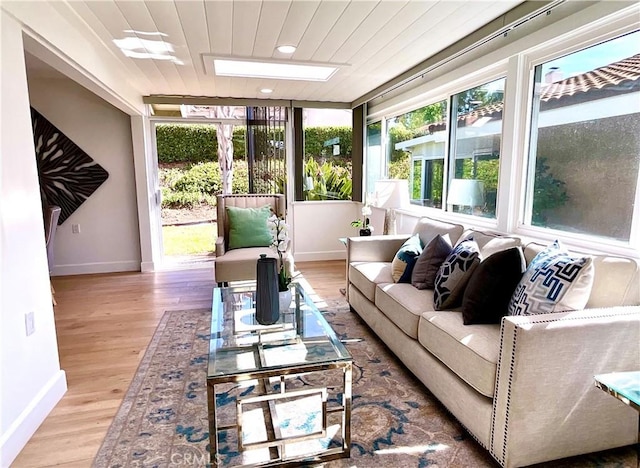 sunroom with a skylight and wooden ceiling