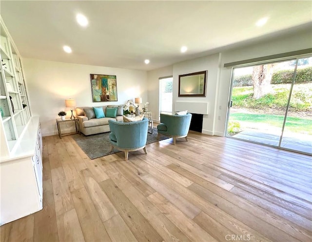 living room featuring recessed lighting, plenty of natural light, and light wood finished floors