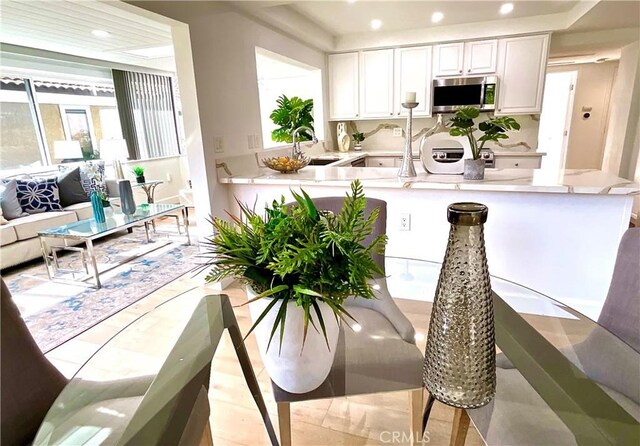 kitchen featuring recessed lighting, light countertops, stainless steel microwave, white cabinetry, and range