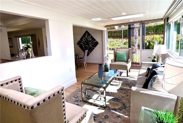 living room featuring plenty of natural light, wood finished floors, and baseboards