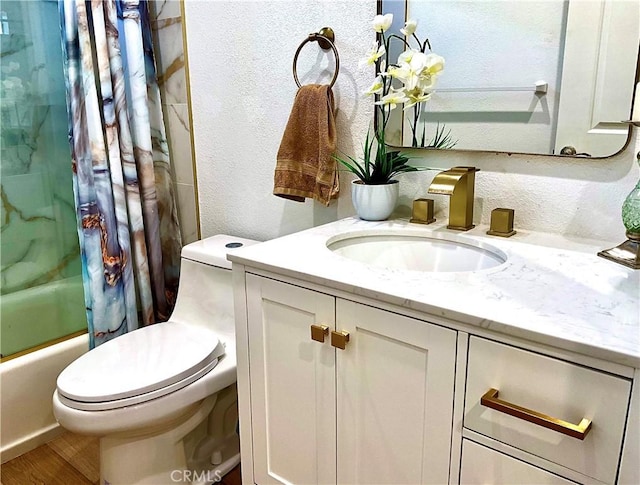bathroom with shower / bath combination with curtain, a textured wall, vanity, and toilet