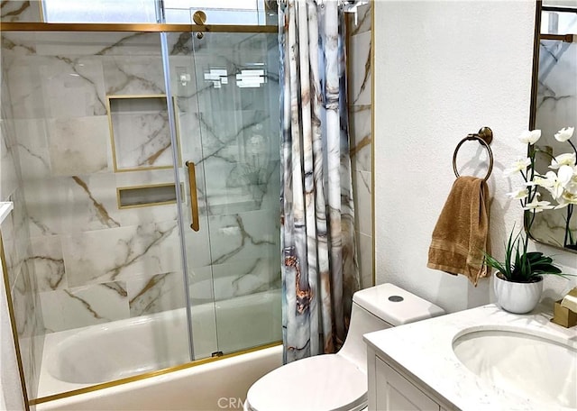 full bath with toilet, a textured wall, bath / shower combo with glass door, and vanity