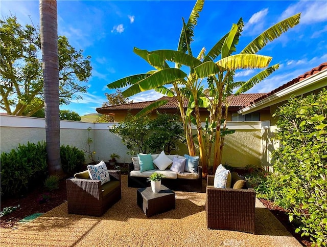 view of patio featuring outdoor lounge area and fence