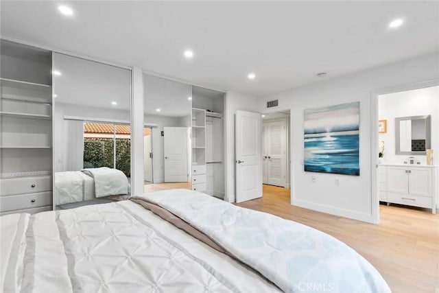 bedroom with baseboards, visible vents, wood finished floors, a sink, and recessed lighting