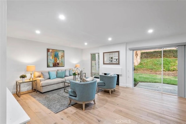 living room with light wood finished floors, baseboards, and recessed lighting