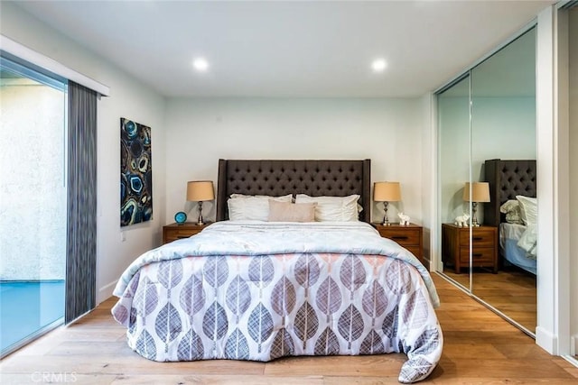bedroom featuring access to exterior, recessed lighting, a closet, and wood finished floors