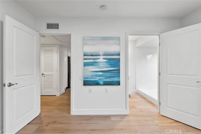 interior space with light wood finished floors, visible vents, and baseboards