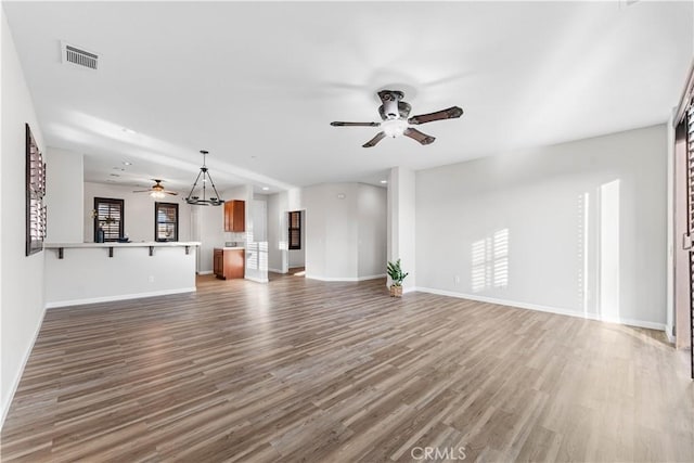 unfurnished living room with ceiling fan and dark hardwood / wood-style flooring