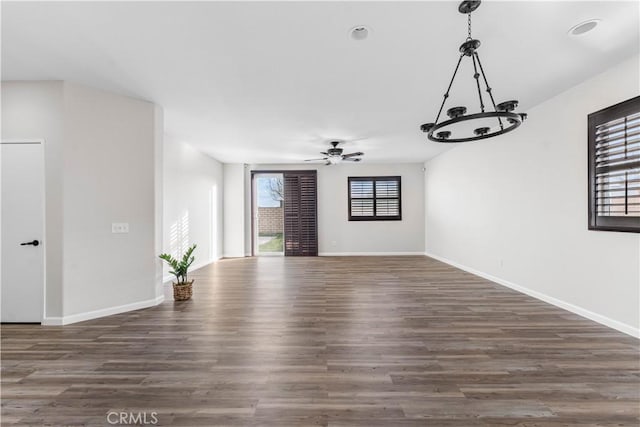 empty room with ceiling fan and dark hardwood / wood-style flooring