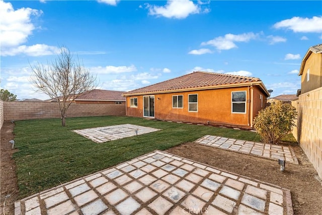 rear view of property with a yard and a patio