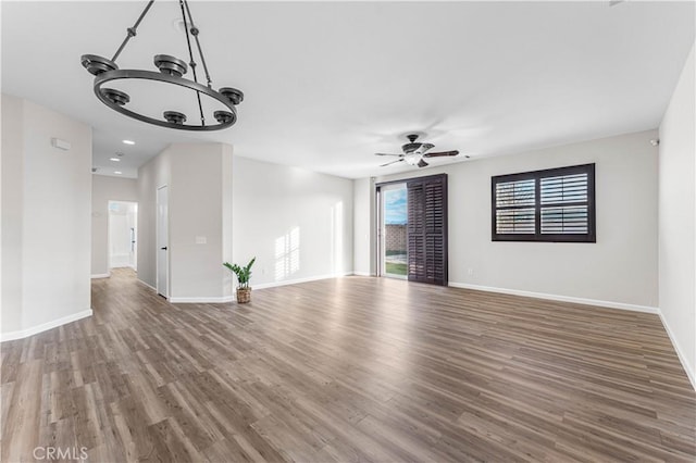 unfurnished living room featuring dark hardwood / wood-style floors and ceiling fan