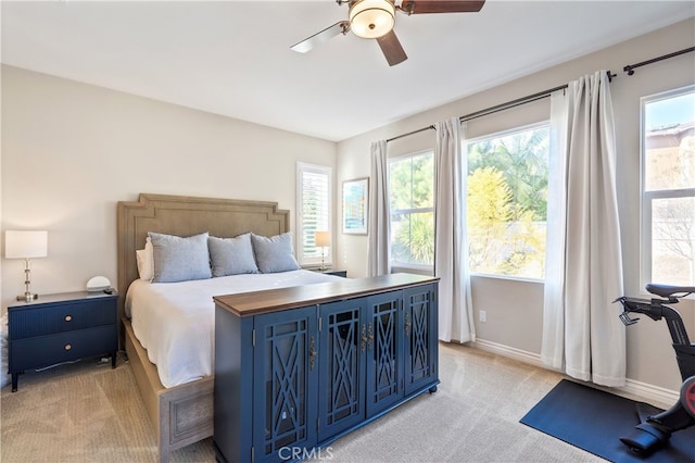 bedroom with ceiling fan and light carpet