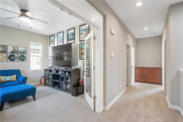 carpeted living room featuring ceiling fan