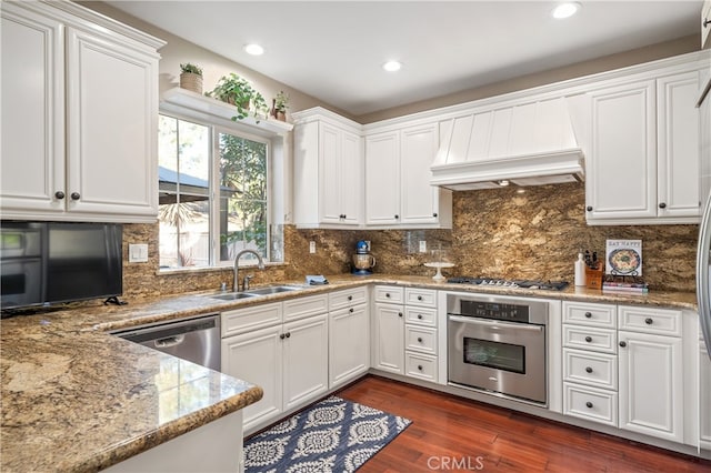 kitchen featuring dark wood-type flooring, appliances with stainless steel finishes, sink, and white cabinets