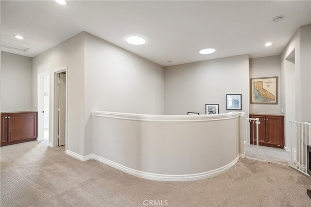 hallway featuring light colored carpet