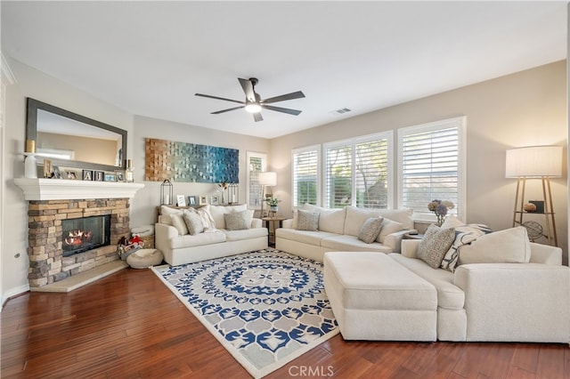 living room featuring ceiling fan, dark wood-type flooring, and a fireplace