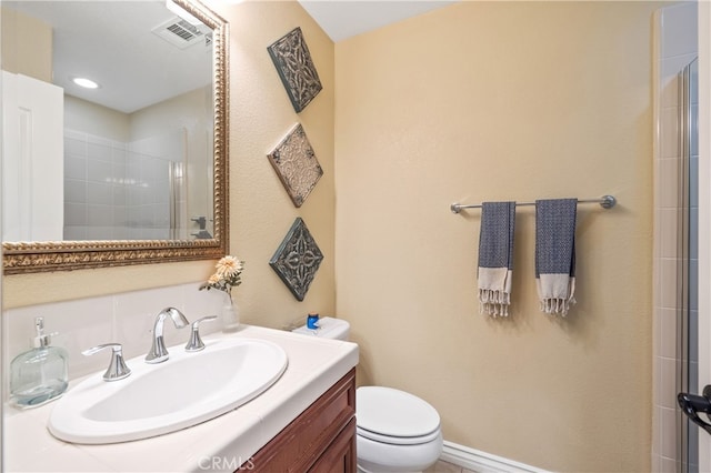 bathroom with vanity, a shower with shower door, and toilet