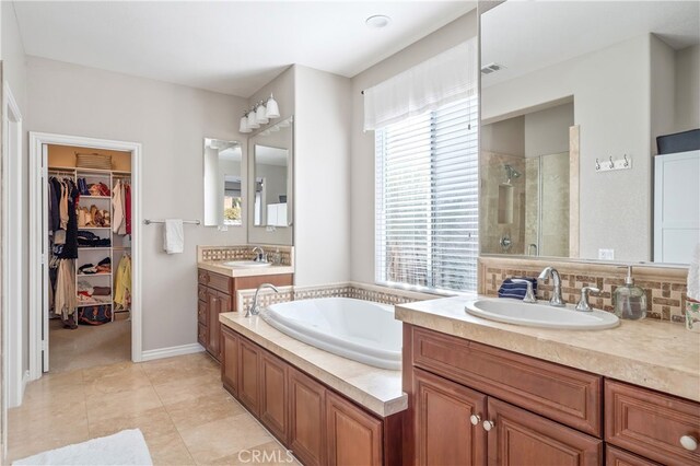 bathroom featuring vanity, tile patterned flooring, and separate shower and tub