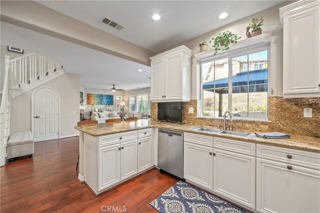 kitchen featuring sink, stainless steel dishwasher, dark hardwood / wood-style flooring, kitchen peninsula, and white cabinets