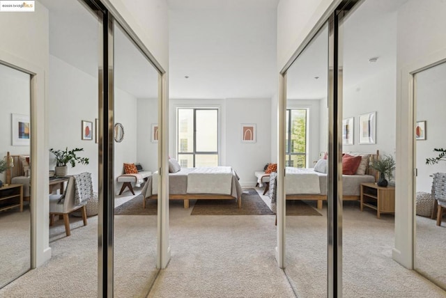 bedroom with light colored carpet and two closets