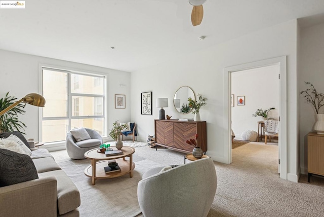 carpeted living room with ceiling fan