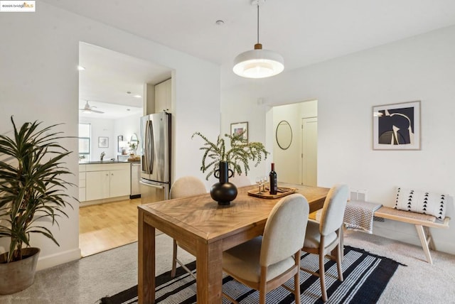 dining area with sink and light colored carpet