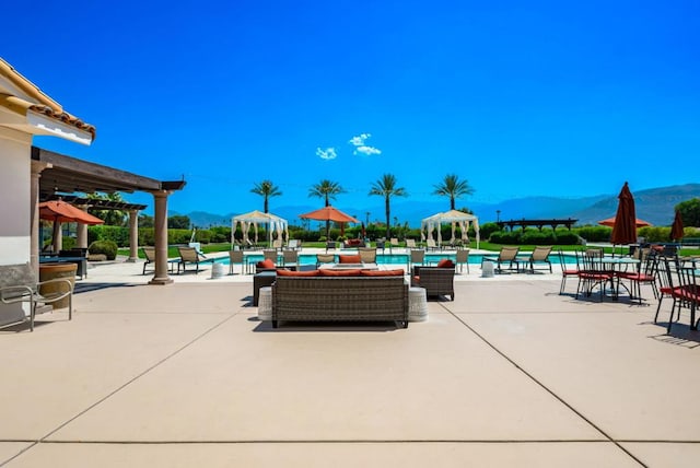 exterior space featuring a pergola, a mountain view, and a patio